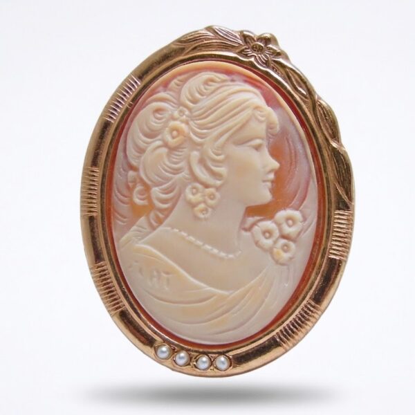 Spilla ciondolo con profilo di dama inciso su conchiglia.