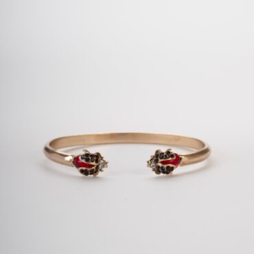 Sfondo chiaro e morbido che mostra perfettamente la simmetria del bracciale e la brillantezza dei cristalli rossi.