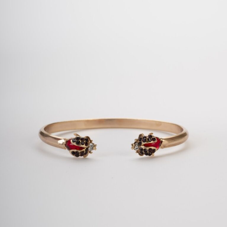 Sfondo chiaro e morbido che mostra perfettamente la simmetria del bracciale e la brillantezza dei cristalli rossi.