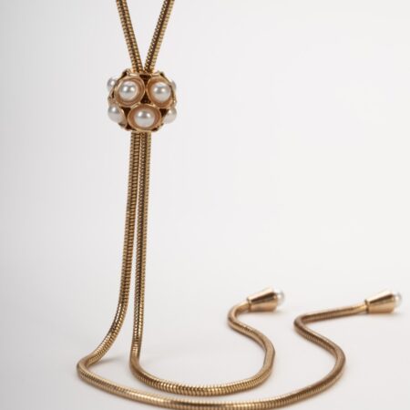 Collana lunga saliscendi placcata oro con pendente a sfera e perle.