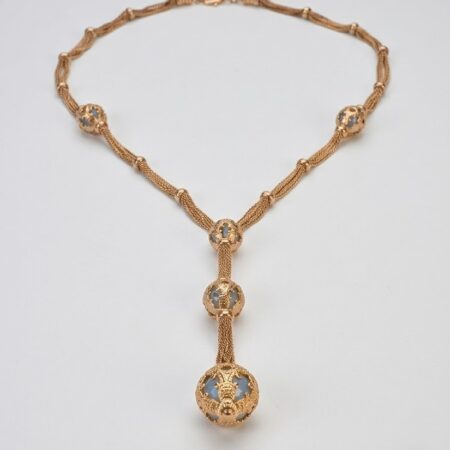 Collana con architetture dorate e sfere filigranate.