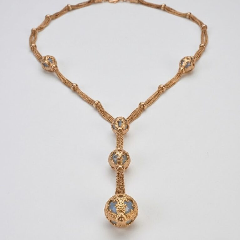 Collana con architetture dorate e sfere filigranate.