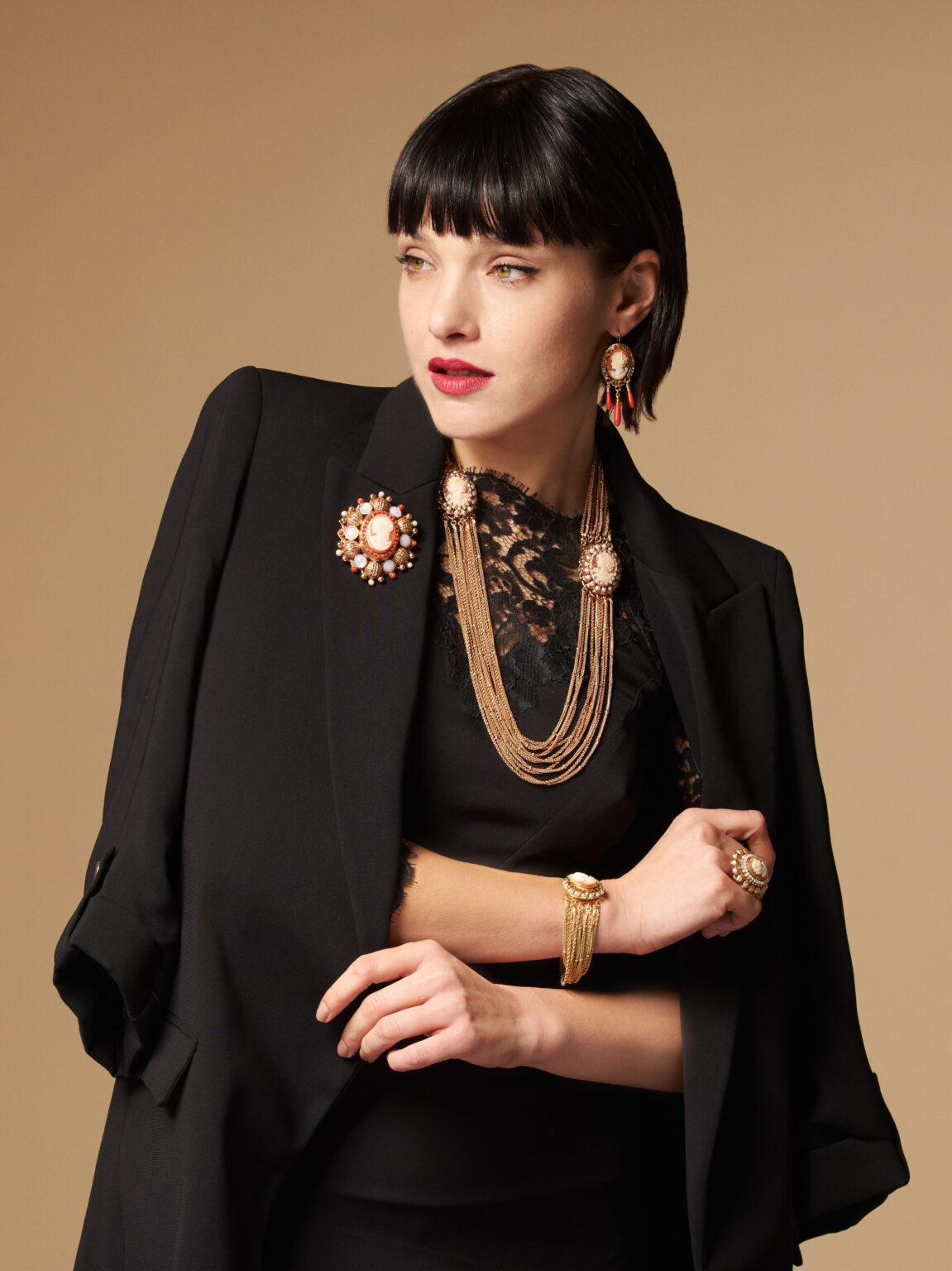Modella che indossa l'intera collezione di gioielli cammeo. Il bracciale spicca su un elegante outfit con giacca.