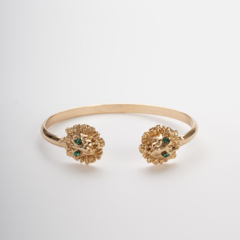 bracciale rigido dorato con due teste di leone e cristalli verdi