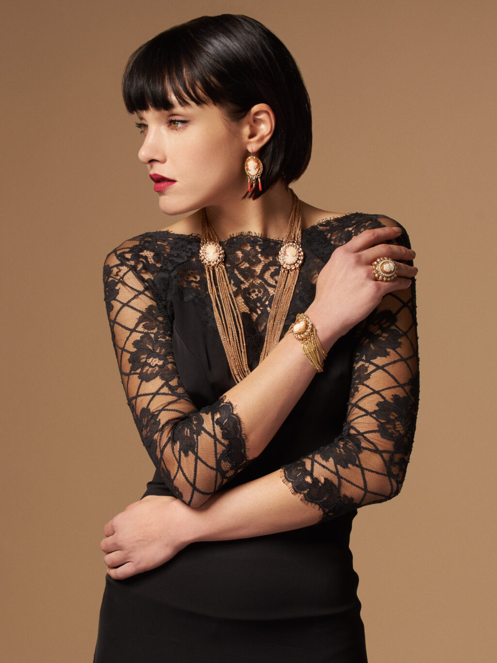 Modella che indossa l'intera collezione di gioielli cammeo, con bracciale e collana in evidenza, abbinati a un elegante abito da sera.