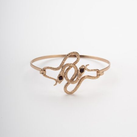 Bracciale rigido dorato con due serpenti intrecciati e occhi di pietre rosse punto luce
