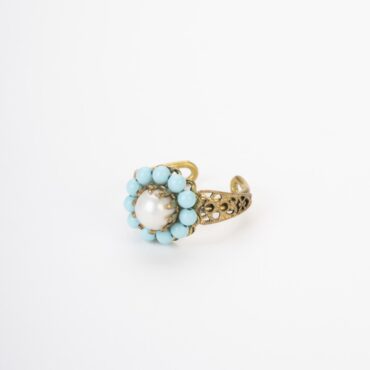 Anello regolabile in ottone con perla d’acqua dolce e aulite su sfondo avorio.