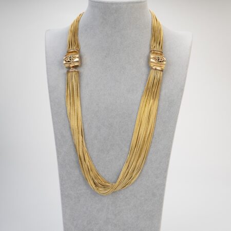 Collana artigianale maestosa in ottone fiammato su busto sartoriale, design materico d'ispirazione templare con cristalli color garnet.