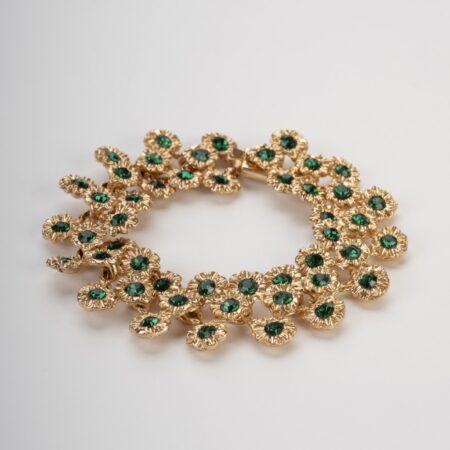 Bracciale pezzo unico dorato stile Art Nouveau con motivi a margherita e cristalli verde smeraldo