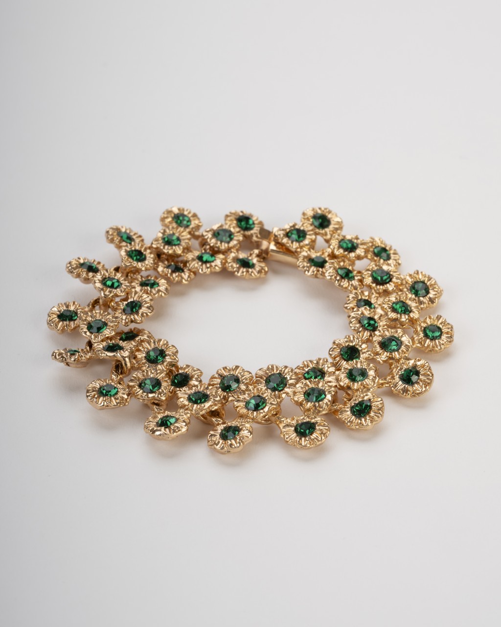 Bracciale pezzo unico dorato stile Art Nouveau con motivi a margherita e cristalli verde smeraldo