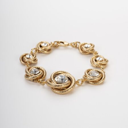 Bracciale a torchon dorato con castoni di cristallo brillante su fondo chiaro