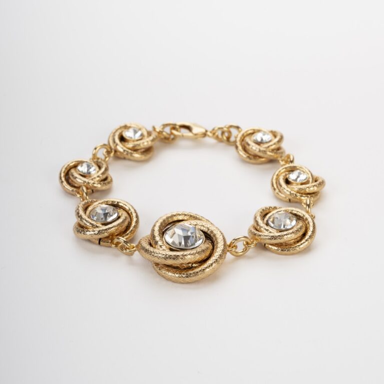 Bracciale a torchon dorato con castoni di cristallo brillante su fondo chiaro
