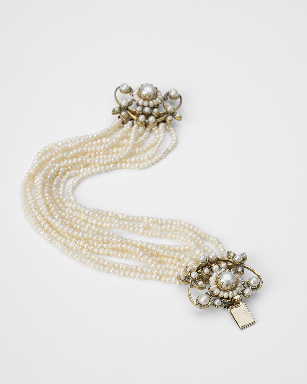 Dettaglio chiusura a scatto nascosta e filigrana in ottone per bracciale di perle